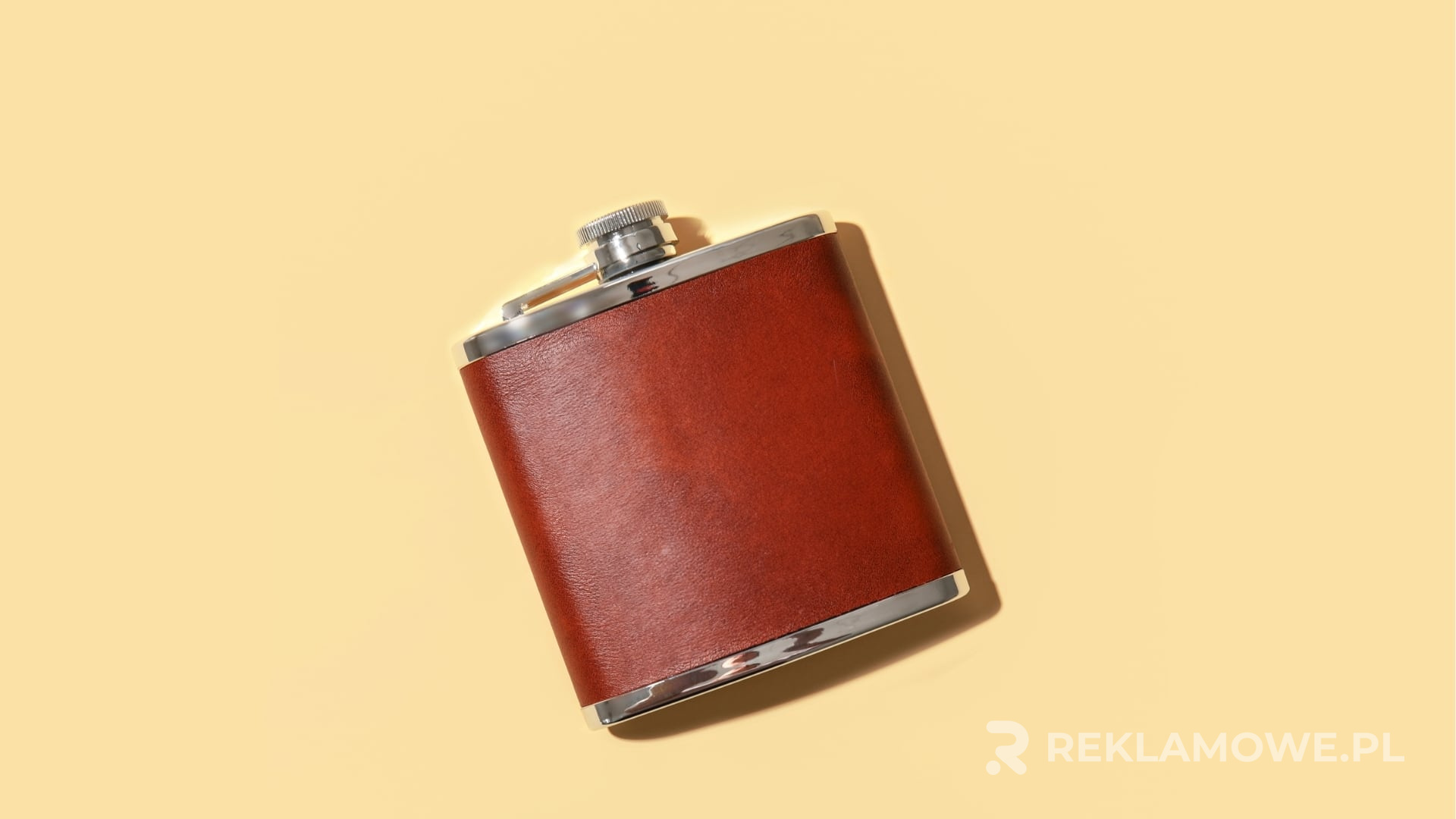 Piersiówka reklamowa na tle drewna